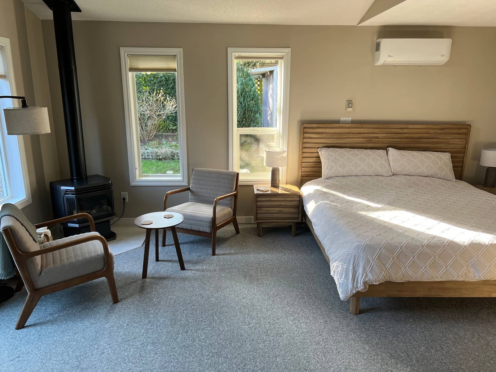 King bed with two nightstands and an armchair in the bright guest suite