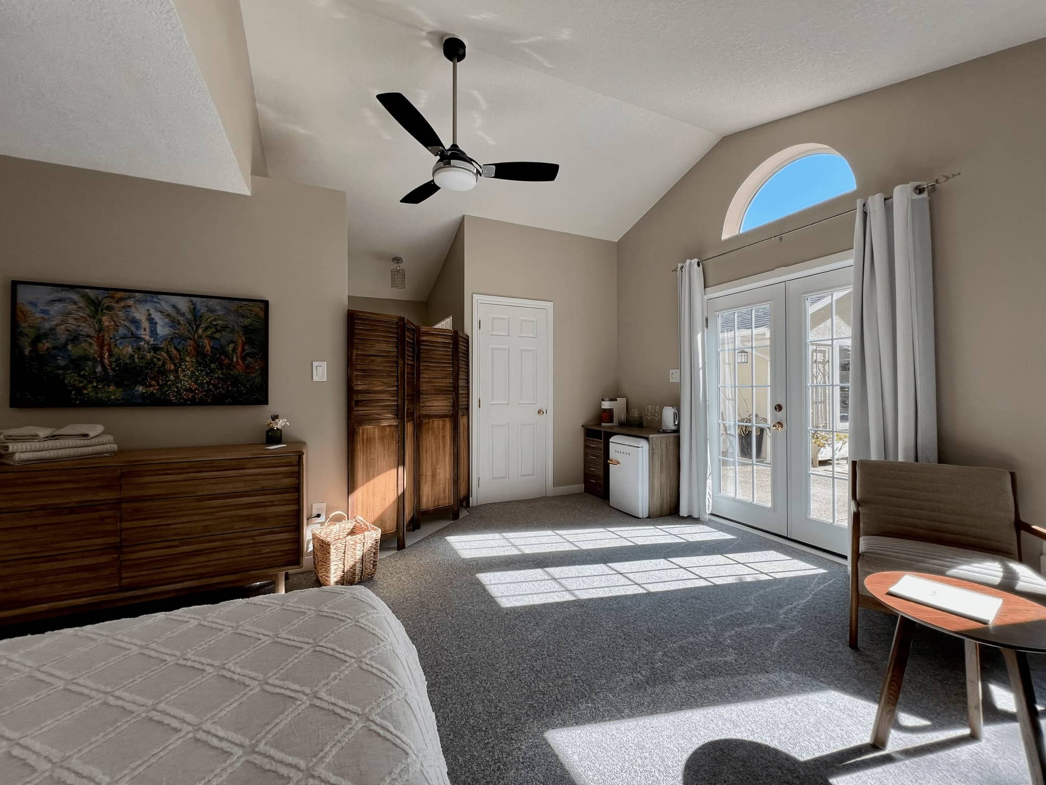 Bright open-concept suite with ceiling fan and natural light