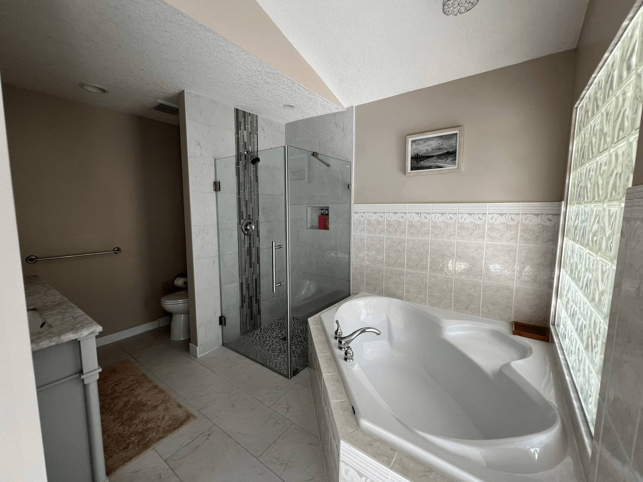 Five-piece ensuite bathroom with corner soaker tub and glass shower