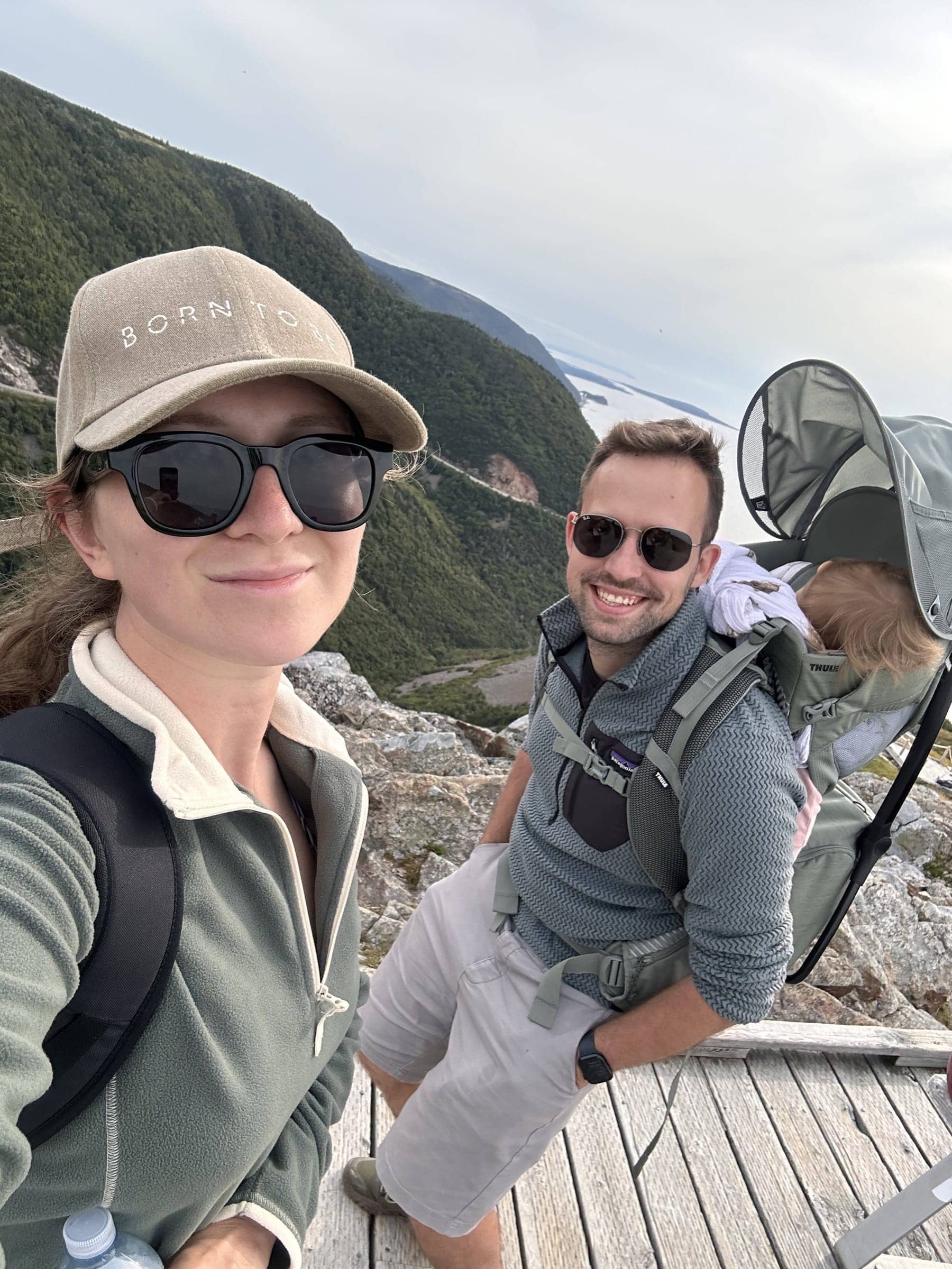 Hosts Anna and Vrat taking a selfie at a boardwalk viewpoint while hiking in Cape Breton, Nova Scotia