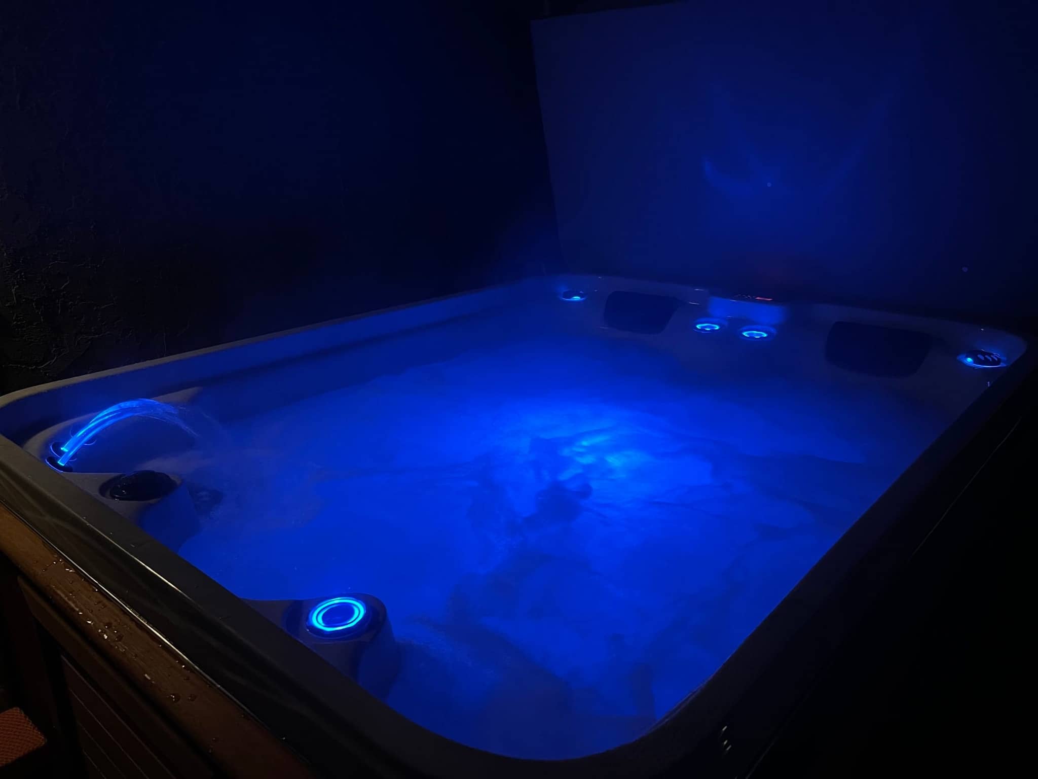 Private hot tub glowing with blue lights in the evening