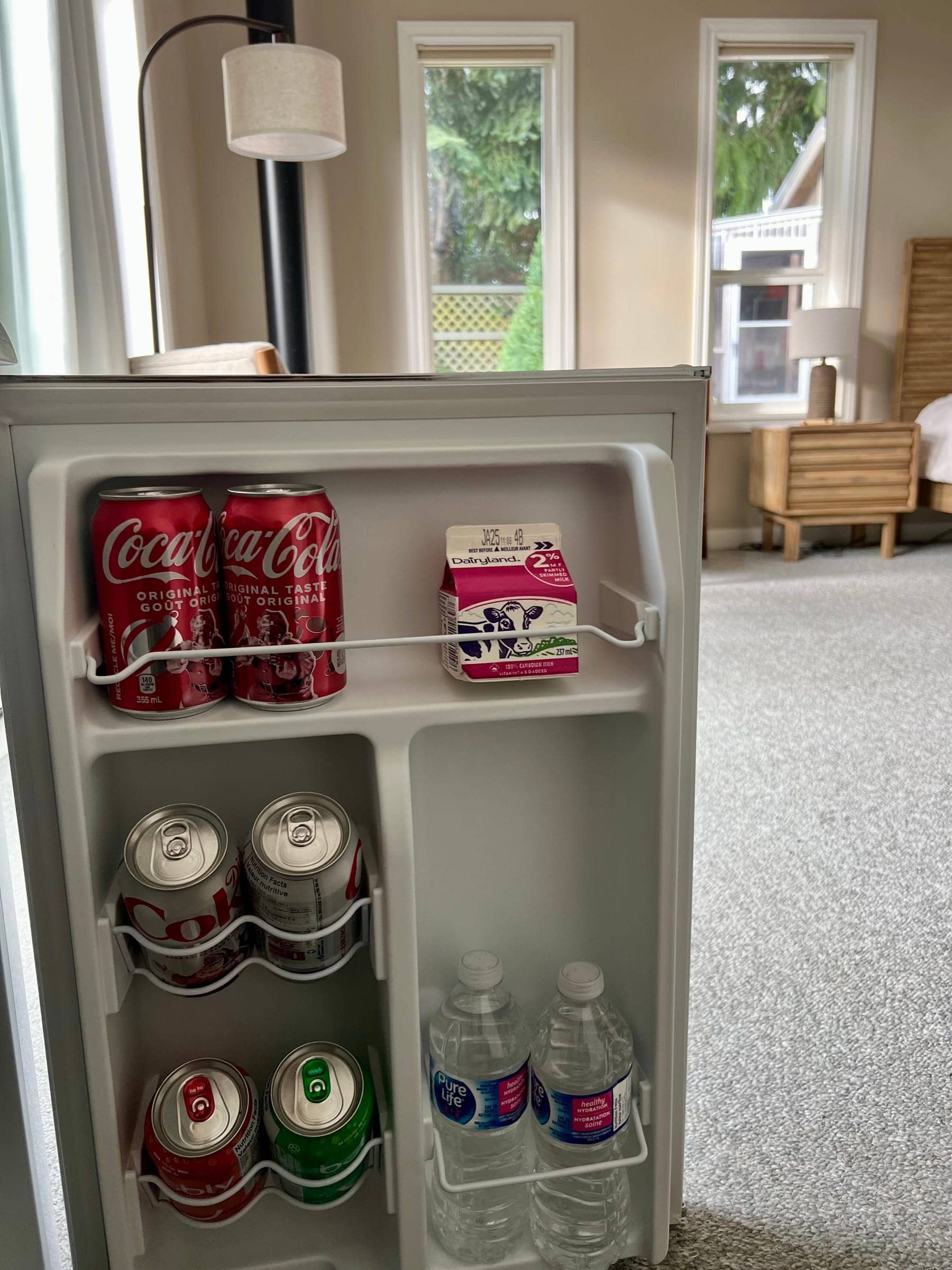 Mini fridge stocked with milk, juice and cold drinks for breakfast